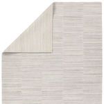 Back side of rug turned corner revealing reverse side with lighter beige stripes