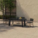 Side angle of the oval table with four woven dining chairs and decorative items outdoors