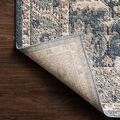 Back corner of Teagan Denim Pebble Rug lifted to reveal woven backing and edge stitching