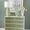 Styled room setting with Maxwell Chest topped with decorative vases and a lamp against green wall