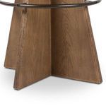Close-up of the tapered wood base panels with visible grain and metal footrest attachment