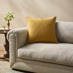 Pillow styled upright on light beige sofa in neutral living room setting