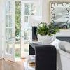 Opposite side view of console table with white floral arrangement on top and mirrored black and gold framed wall art