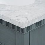 Detail of white Carrara marble countertop corner with veining and fluted wood trim underneath
