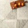 close-up of rug texture next to wooden cutting board with citrus fruit