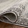 Rolled edge of rug showing thickness, soft texture, and craftsmanship in charcoal and pebble tones