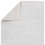 Back side of Mona rug folded to show reversible striped pattern and flat weave
