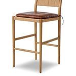 Angled close-up of stool frame showcasing toasted ash wood grain and woven seat detail