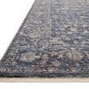 Close-up side angle showing rug’s low pile and fringed edge in natural fiber color