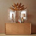 Living space setting with Margot Credenza styled under large decorative mirror and hanging leaf chandelier