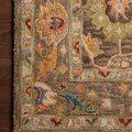 Top-down close-up revealing dense pile and intricate floral patterns near the edge of Padma Charcoal Multi Rug on hardwood...