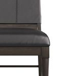 Close-up frontal view of padded black leather seat and dark wooden frame edges
