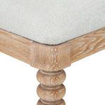 Close-up of almond cerused oak wood grain texture and corner of white upholstered seat
