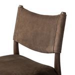 Close-up of leather backrest showing stitched edges and wood frame connection