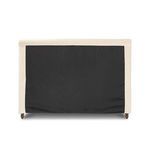 Rear view of Dalia Bed showing black underside lining beneath cream fabric slipcover