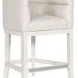 Side angle showing textured white fabric upholstery and footrest on Emmett Performance Wood Flare Base Stool