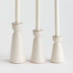 Side view of three stoneware taper holders lined up by height, highlighting their tapered cylindrical shapes and smooth gl...