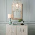 Single medium pendant viewed from side, hung above cabinet with mirror and small bonsai plant