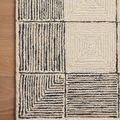 Close-up of Francis rug corner showing thick textured wool loops and detailed black and cream grid design