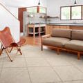 Sawyer Sand Rug styled in modern open living room with wood floor, tan sofa, and leather chair