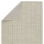 Rug corner flipped showing solid light gray backing behind the striped wool surface