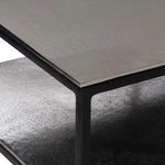 Close-up of nickel-finished tabletop corner and matte black iron frame joint