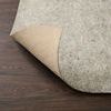 Rug pad corner flipped to reveal beige non-slip textured underside
