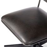 Close-up detail of thick padded seat cushion with matte black iron frame edges