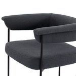 Black iron legs with rectangular footrest detail under slate boucle seat cushion