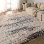 Living room setting with rug placed under beige sofa by sunlit window