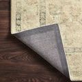 Rosette rug corner lifted to reveal tightly woven fabric backing with herringbone pattern