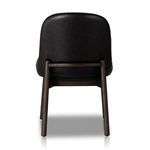 Back view of black leather armless dining chair with visible wood support bar