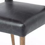 Close-up of squared seat corner upholstery and wood grain on front leg