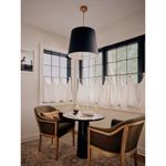 Side view of the black linen shade pendant above dining table with window backdrop