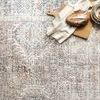 close top view of rug surface with bread, kitchen towel, and dishes as styling accents