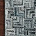 Close-up of Prescott Arctic Blue Rug corner showing hooked pile texture against dark hardwood floor