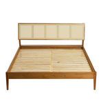 Front view of queen bed showing full width of woven cane headboard and wooden frame