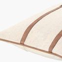 Close-up angled view showing texture of linen fabric and smooth vegan leather straps on the pillow