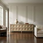 Sideboard in classic interior with wood floors and paneled white walls, decorated with vases and books