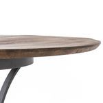 Tilted close-up emphasizing thickness of wood tabletop and seamless connection to iron base