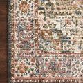Close-up detail of the rug's multicolored floral border laid on dark hardwood floor