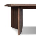 Close-up of rounded table base corner with visible wood grain and base feet