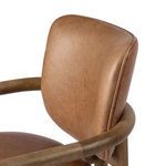 Close-up of caramel leather barrel backrest with visible stitching detail