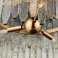 Close-up showing antique brass center sphere and sockets with clear icicle-like glass bars surrounding