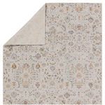 Back side of the rug folded to show underside weave and pattern in muted tones