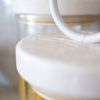 Close-up detail of white iron top lid’s textured surface and round handle