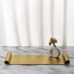 Antique gold scroll tray styled as centerpiece on marble surface with white curtain background