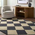 rectangular rug laid in living room with beige armchair, wooden console table, and charcoal-beige diamond pattern