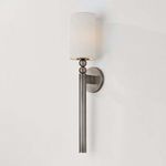 Lakeport Wall Sconce illuminated on white wall with soft glowing cylindrical shade