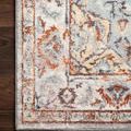 Close-up of rug corner on dark hardwood floor highlighting detailed border and texture